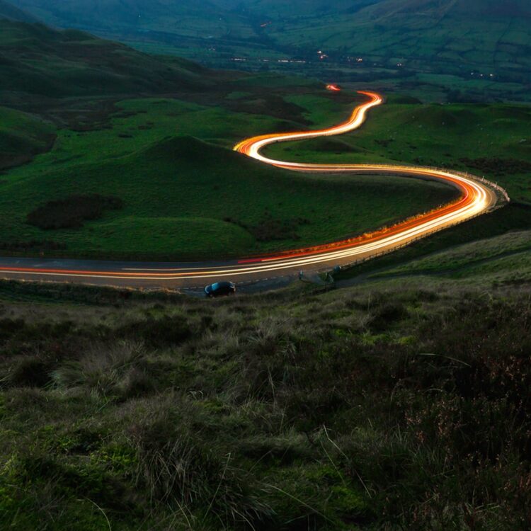 Aerial view of road between green grass field 3635300