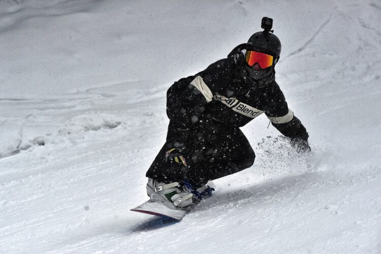 Person in black jacket and black pants riding on snowboard 3869851