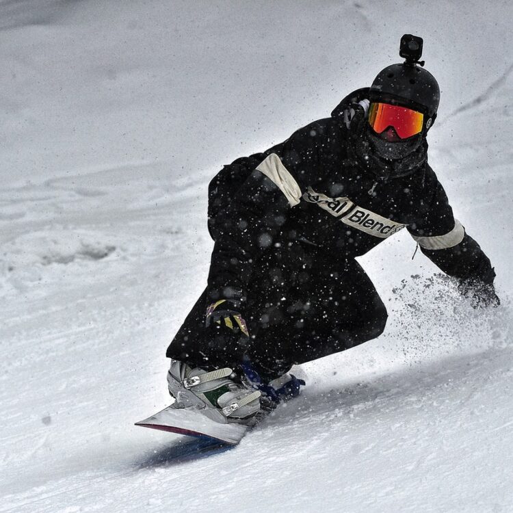 Person in black jacket and black pants riding on snowboard 3869851