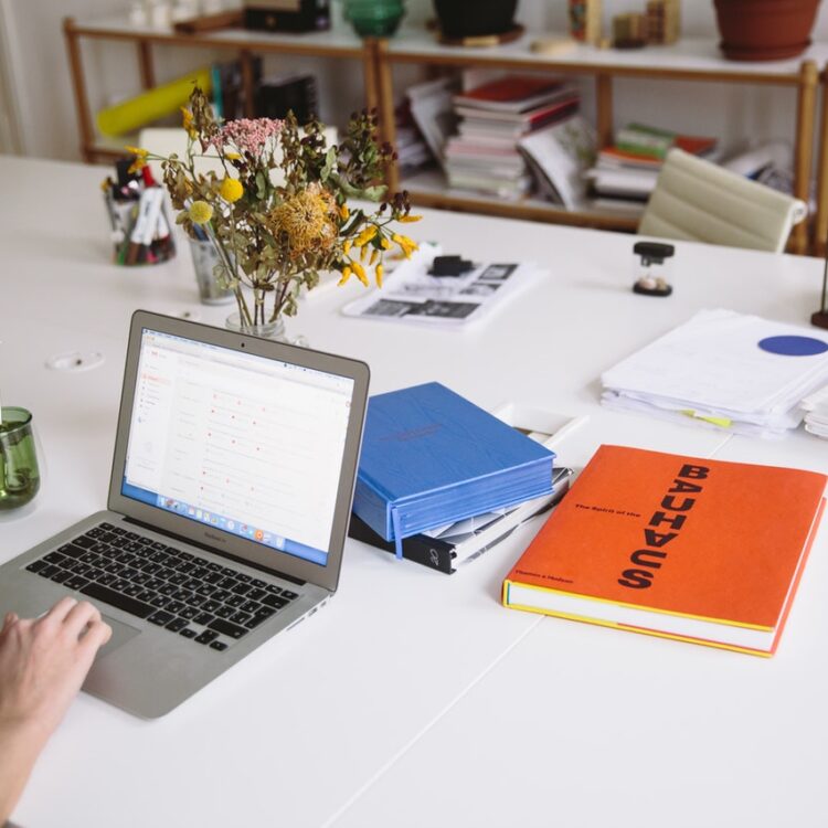 Photo of orange book beside laptop 3747455