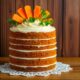 Carrot cake with cream cheese and mint leaves on a wooden table