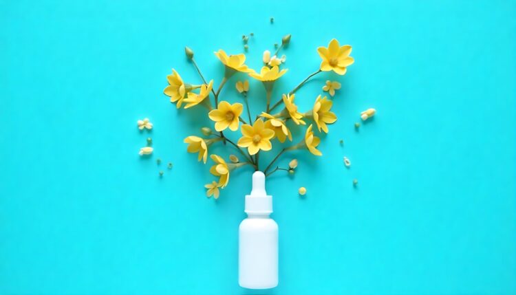 Cosmetic products on yellow background with blooming cherry