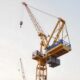 Crane and building construction site against blue sky isolated on white background professional