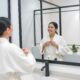 A dark-haired young girl in a white bathrobe in the bathroom