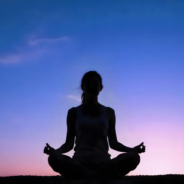 A Person Meditating On A Lake With The Sun Behind Them