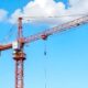 Red construction tower crane against blue sky tower crane